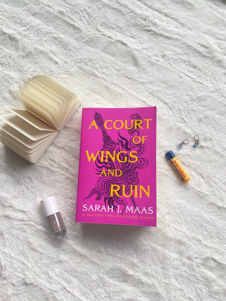 a court of wings and ruin flatlay with olive and june